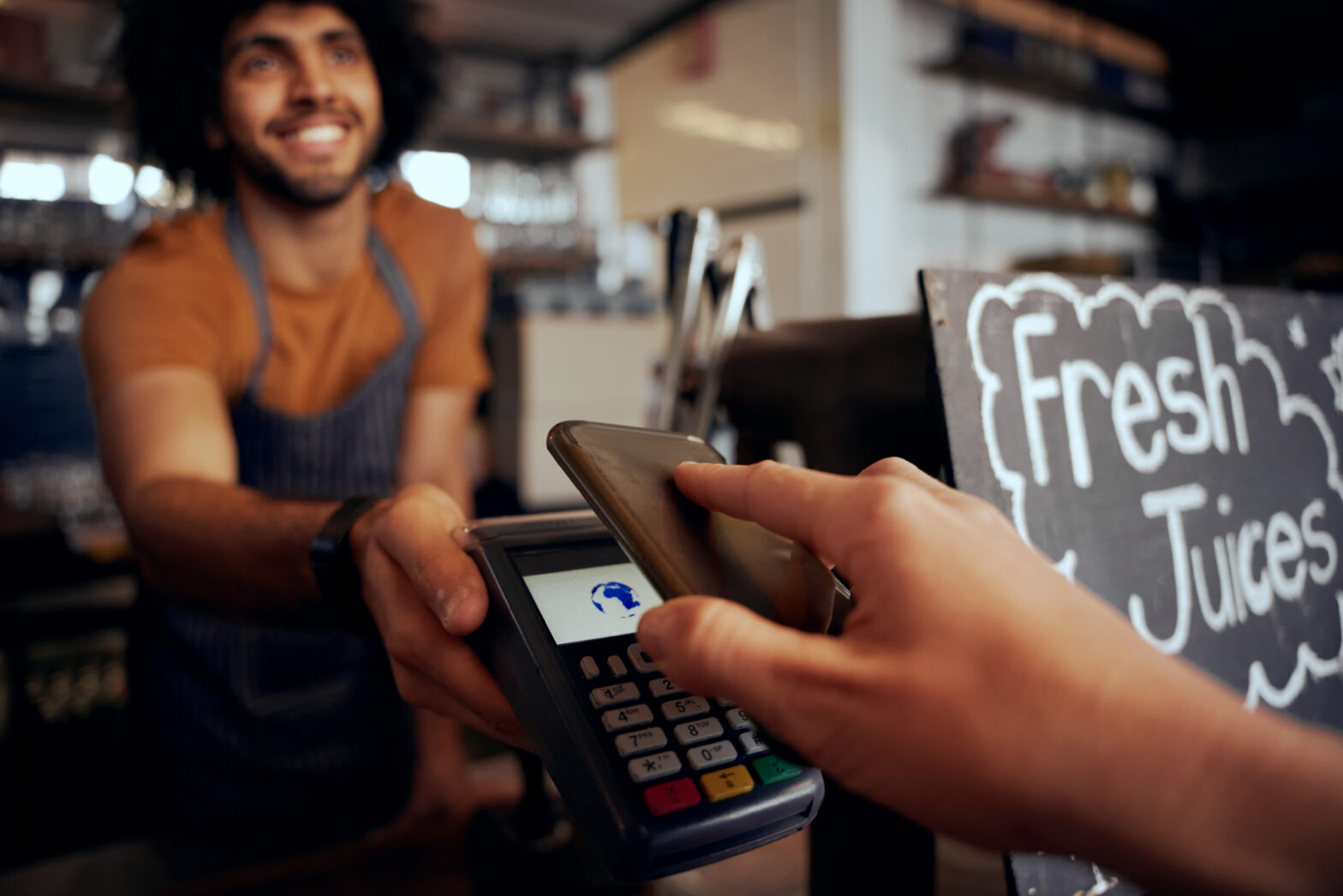 UK small business owner accepting contactless card payment
